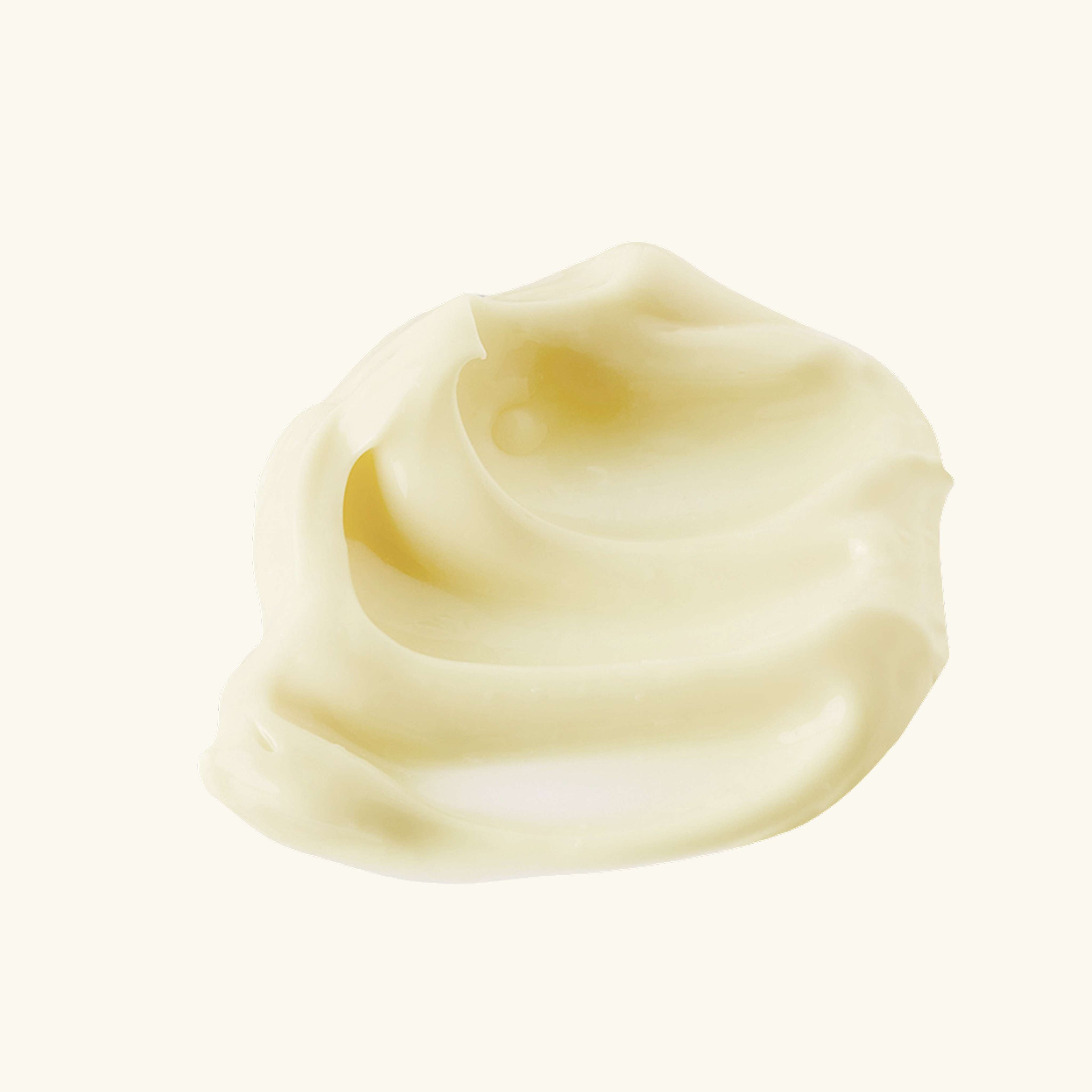 Smooth texture of advanced brightening moisturizer on a pale background.